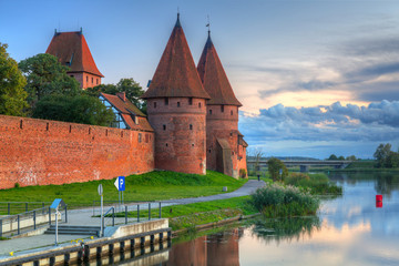 Naklejka premium Malbork castle over the Nogat river at sunset, Poland