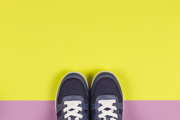 Grey sneakers on the violet and yellow background. Concept for healthy lifestyle and everyday training.