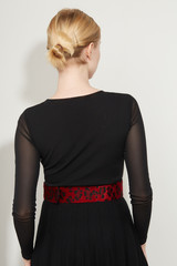 Cropped back view shot of a blond girl, posing on a white background. She is wearing black gown...