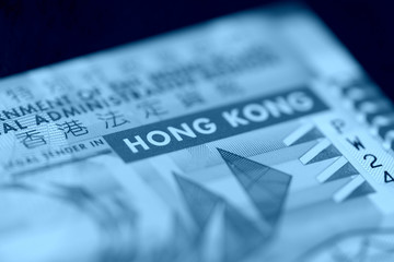 Ten Hong Kong dollars bill on a dark background close-up. Blue color toned