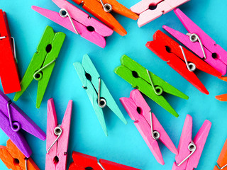 many colored clothespins on a blue background, as a substrate, pin; clothes peg - obrazy, fototapety, plakaty