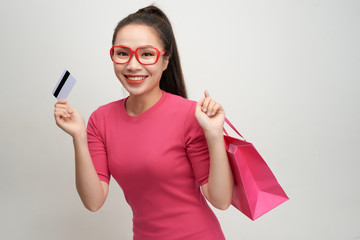 Image of excited screaming young woman standing holding shopping bags and credit card.