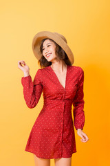 Asian girl wearing red dress with straw hat over orange background