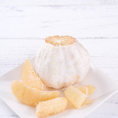 Fresh peeled pomelo, pummelo, grapefruit, shaddock on bright wooden table background. Seasonal fruit for Mid-Autumn Festival, close up, copy space.