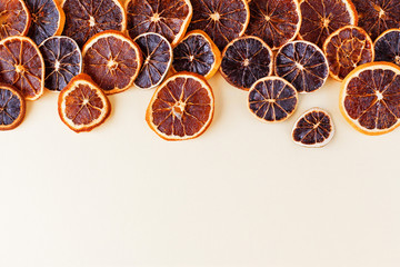 Dried slices of oranges, lemons and grapefruits for making hot drinks or decoration. Dried citrus fruits, Christmas decor on a light background. Frame on one side. Copy space, flat lay.