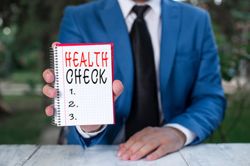 Text sign showing Health Check. Business photo text Medical Examination Wellness and general state Inspection Man holds empty paper with copy space in front of him