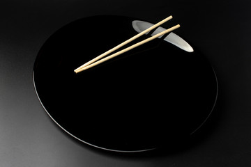 black empty plate with chinese chopsticks