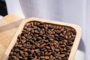 coffee beans and wooden plate on the table near the window