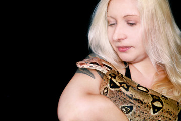 Portrait of girl with Boa constrictor snake. Beautiful woman holds snake in hands and posing in...