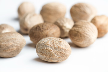 Especias de Nuez moscada sobre fondo blanco aislado vista de frente