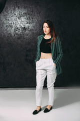 mature stylish brunette in a green jacket posing in the studio