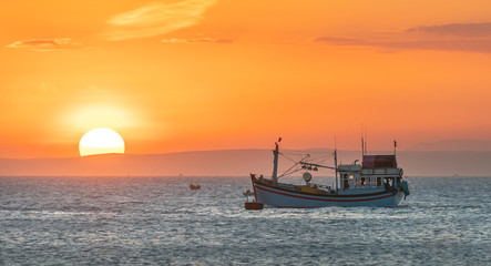 Fototapeta premium Sea landscape at sunset when fishing boats out to sea to harvest fish end the day.
