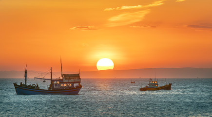 Fototapeta premium Sea landscape at sunset when fishing boats out to sea to harvest fish end the day.
