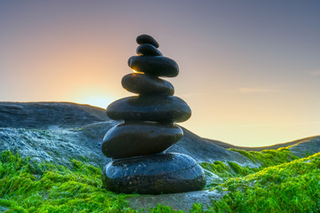 Stacked Pebbles art on mossy rocks welcomes beautiful new day