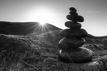 Stacked Pebbles art on mossy rocks welcomes beautiful new day