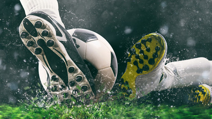 Football scene at night match with close up of a soccer shoe hitting the ball with power - obrazy, fototapety, plakaty