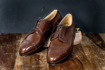 Stilleben Handgemachte braune Schuhe auf Holztisch