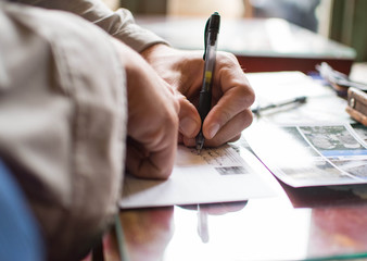 Man is writing a postcard at the table. Traveler life. Connection.