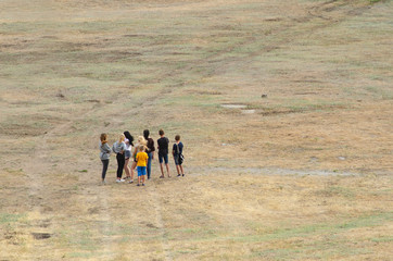 children crowd stand back in the middle of the field