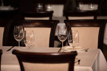 Served table in restaurant, focus on near glass and plate