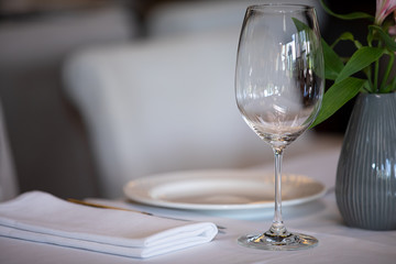 Served table in restaurant, focus on near glass and plate