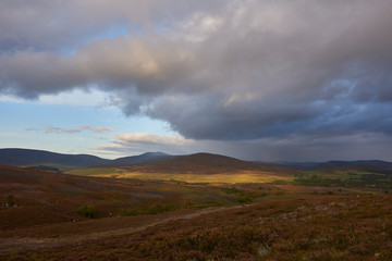 Looking across the Angus Glens towards the small Village of Tarfside in the Valley below, with the evening sun casting a golden light on the Hills.