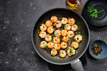 Top view of fried prawns in a pan on black table
