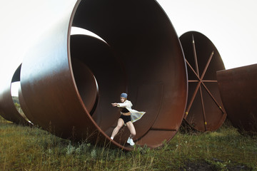Urban hip hop style dancer practicing dance moves in industrial zone.