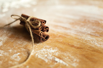Cinnamon sticks and meal close up on wooden table
