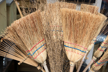 close up wicked brooms in barn