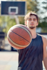 Photo of athlete in blue T-shirt with ball in his hands on sports field.
