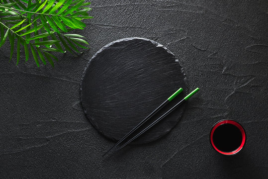 Chopsticks and bamboo bowl on black rock slate plate