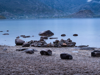 rocas junto a lago de glaciar al amanecer
