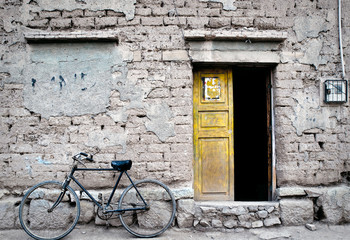 Fototapeta na wymiar Una bicicleta vieja aparcada delante de una casa vieja en Oruro, Bolivia