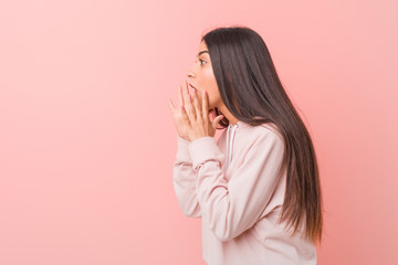 Young pretty arab woman wearing a casual sport look shouts loud, keeps eyes opened and hands tense.