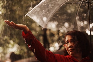 Elderly woman with umbrella in rainy day 