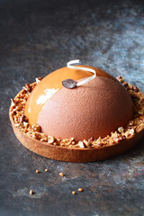 Contemporary Caramel, Walnut, Apple Cake Tart, covered with velvet spray and caramel glaze, on dark...