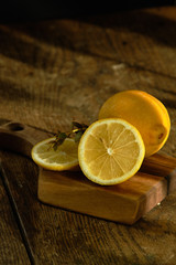 Sliced lemon and eucalyptus lie on a wooden board.