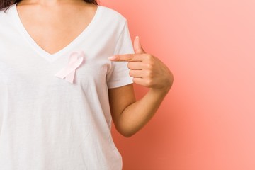 Close up of a young arab woman with a pink bow. Concept of fight against cancer.