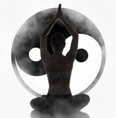 Silhouette young woman practicing yoga, Yin Yang symbol at background