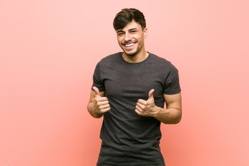 Young hispanic casual man raising both thumbs up, smiling and confident.