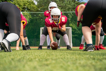 Photo of sportive women playing american football on green lawn