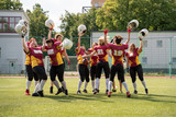 Full length photo of woman rugby team with raised hands looking at camera