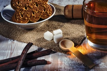 still life with tea mug, sugar and cookies on a wooden table