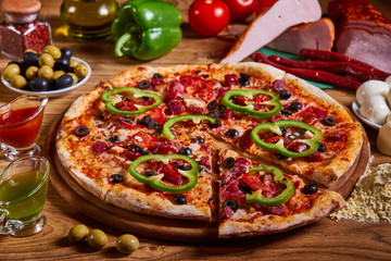 Delicious italian pizza served on wooden table. sliced pizza. tasty pizza composition