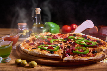 Delicious italian pizza served on wooden table. sliced pizza. hot steam on pizza and place for text. copy space