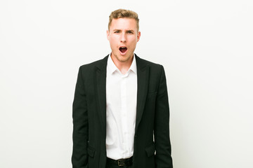 Fototapeta premium Young caucasian business man screaming very angry and aggressive.