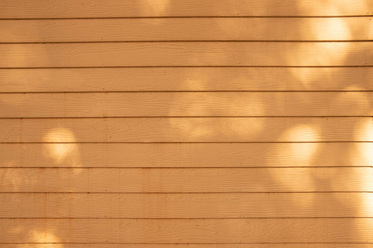 Sunlight and shadow on surface of yellow shera wood wall background on home decorations concept