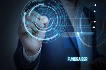 Conceptual hand writing showing Fundraiser. Concept meaning demonstrating whose job or task is seek financial support for charity Male wear formal suit presenting presentation smart device