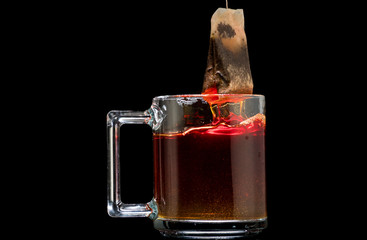making black tea from a bag with sugar in motion on a black background